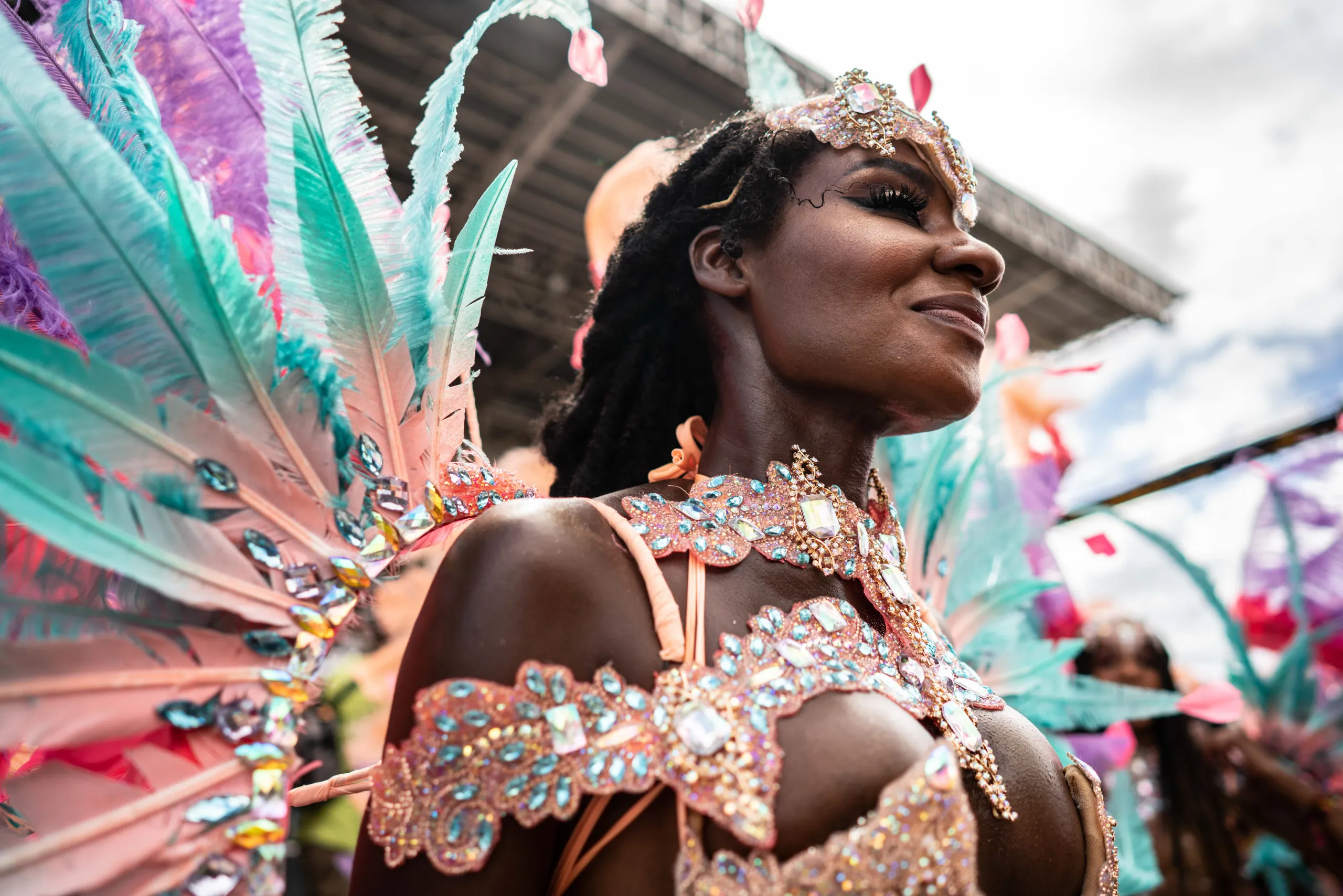 A masquerader in coral feathers and a jewelled costume