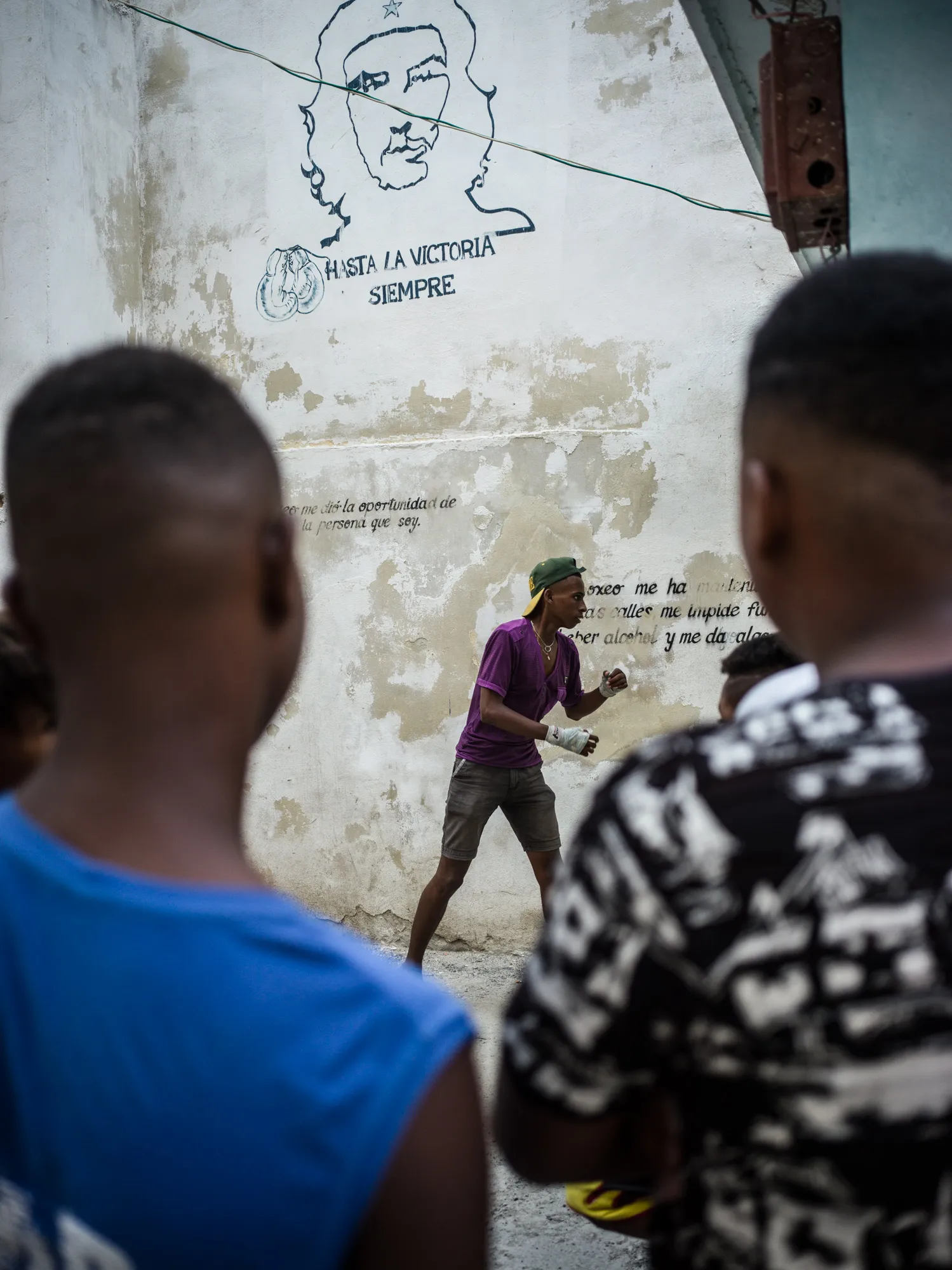 Two boys sparring under a drawing of Che Guevara