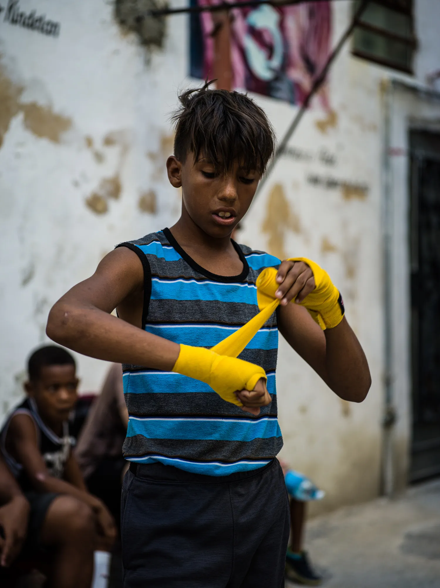 A young boxer with yellow hand wraps