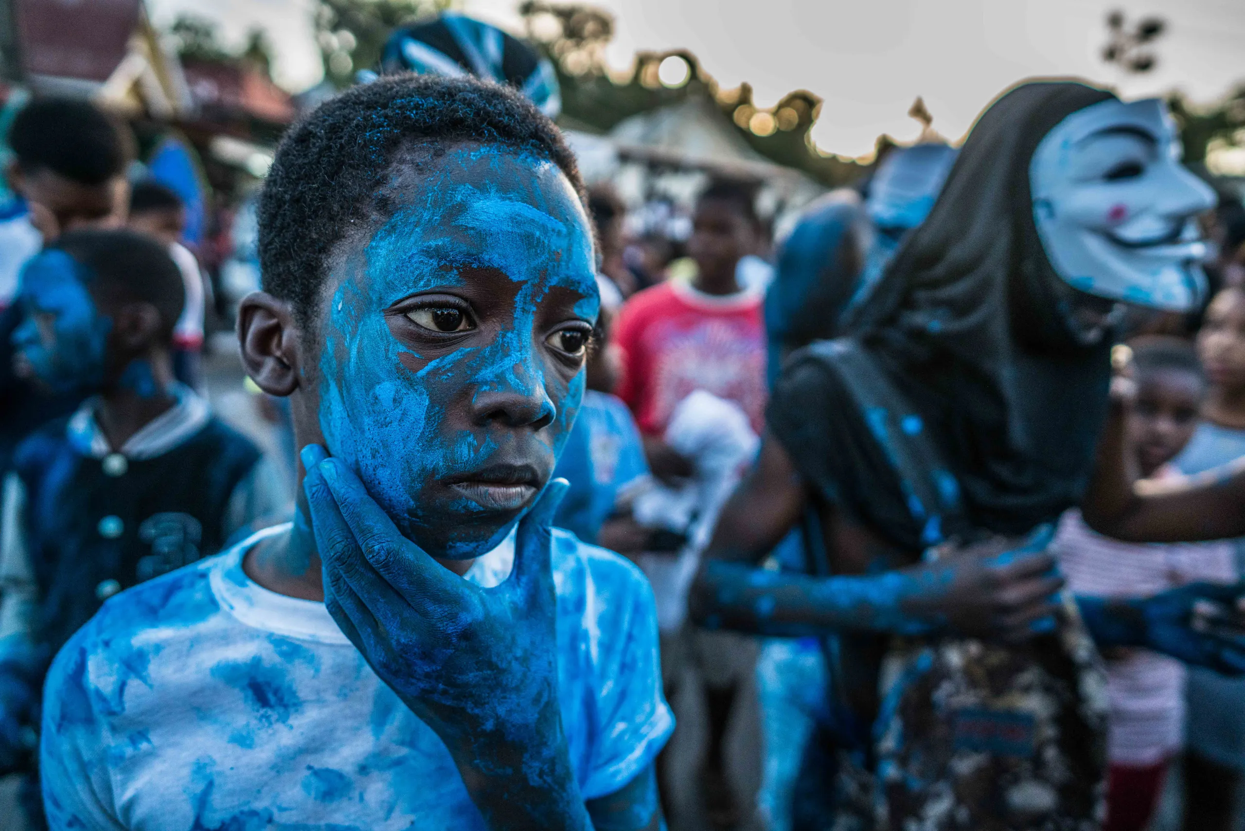 A boy with his face painted blue at J'Ouvert